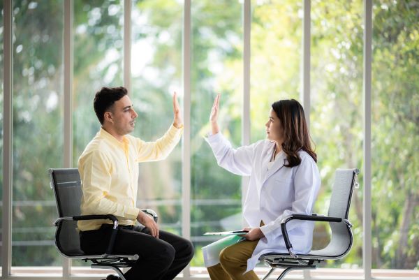 Pacjent oraz psycholożka uchwyceni w momencie przybicia sobie rąk